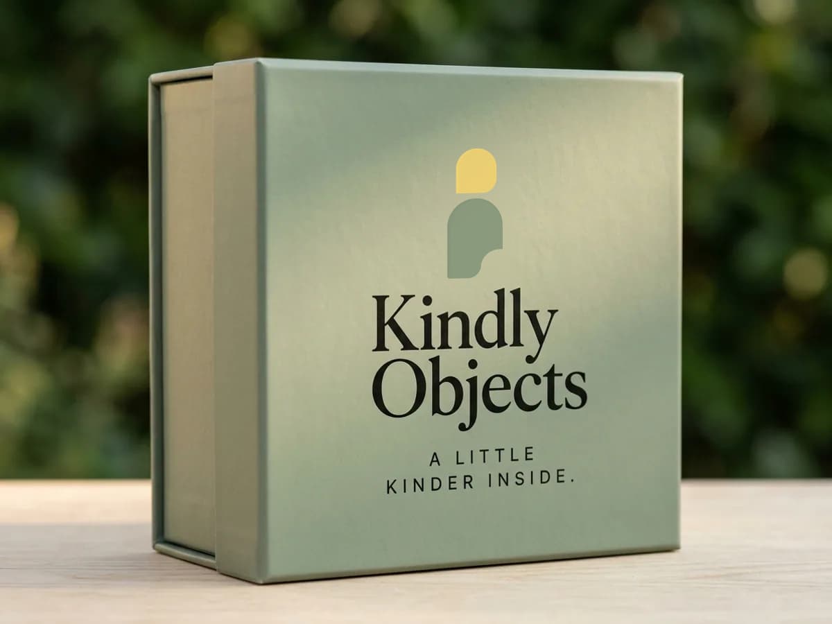 Sage gift box printed with the Kindly Objects icon and wordmark — AI concept render